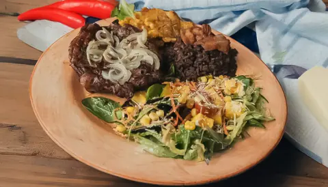 Plato criollo con carne encebollada, arroz moro y ensalada